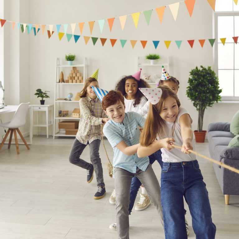 Hier ist eine Gruppe von Kindern die Tauziehen spielen auf einem Kindergeburtstag. 